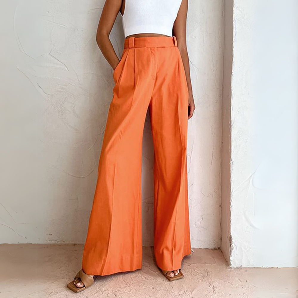 Dieses Foto zeigt ein Modell, das eine stilvolle, orangefarbene, weite Hose trägt. Die Hose ist hoch tailliert und fließt elegant,
