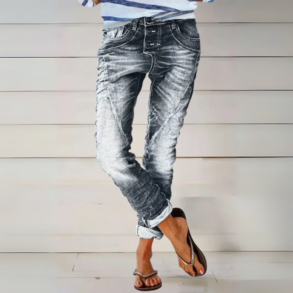 Frau trägt graue Waschjeans mit auffälliger Knopfleiste, elastischer Passform und modischen Umschlägen.