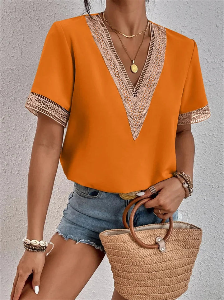 Orangefarbene Bluse mit V-Ausschnitt und Häkelspitze – leuchtend und sommerlich