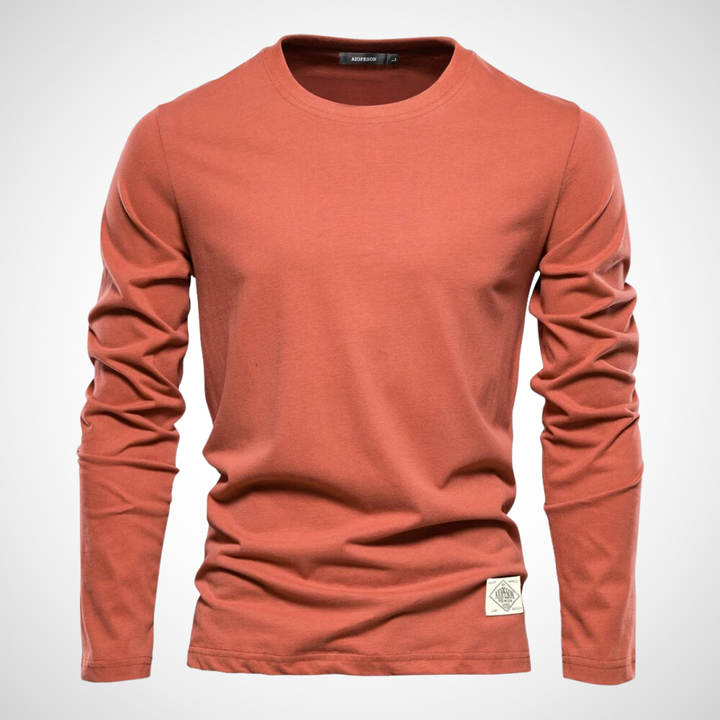 Langarmshirt in Orangefarben mit klassischem Rundhalsausschnitt, atmungsaktivem Baumwollmaterial und schlichten, einfarbigen Design für Herren.