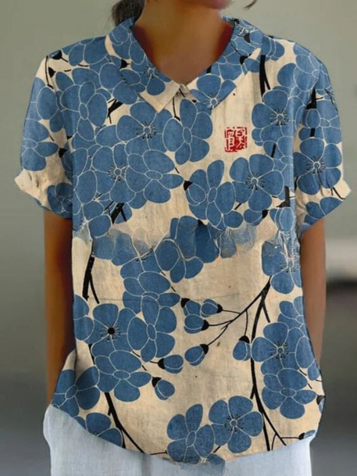 Elegantes weißes Blumenbluse für Damen mit blauen Blumen, das einen frischen und schicken Look bietet, ideal für legere Tage oder Tagesveranstaltungen