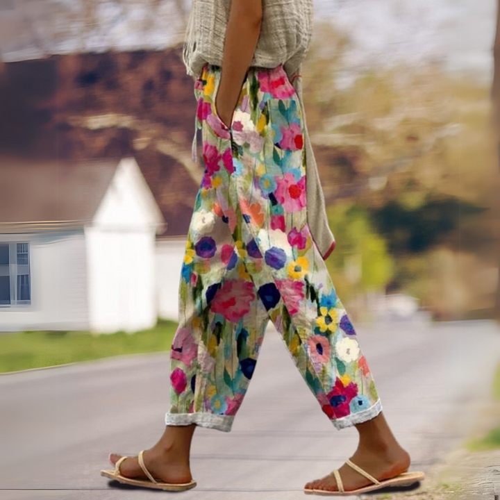 Damenhose in Seitenansicht beim Gehen mit lebendigem Blumenmuster als entspannte Gummibund Hose