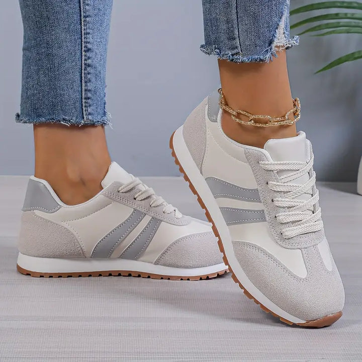 Sneaker mit verstärkter Schnürung, seitliche Streifenelement und griffige Laufsohle für Damen.
